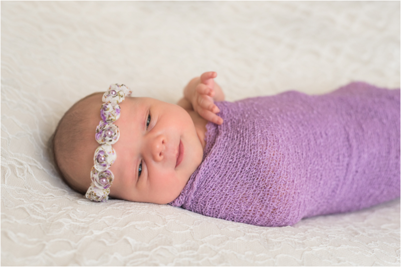 Newborn-baby-girl-in-home-newborn-studio-and-lifestyle-portrait-photography-session-richmond-virginia-purple-wrap-white-lace-backdrop-pearl-flower-headband